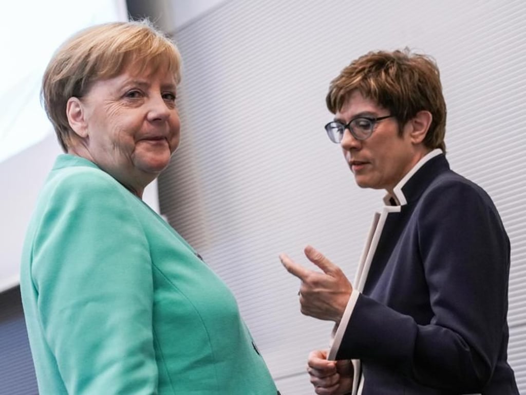 Angela Merkel und Annegret Kramp-Karrenbauer sprechen vor einer Fraktionssitzung. Foto: Michael Kappeler