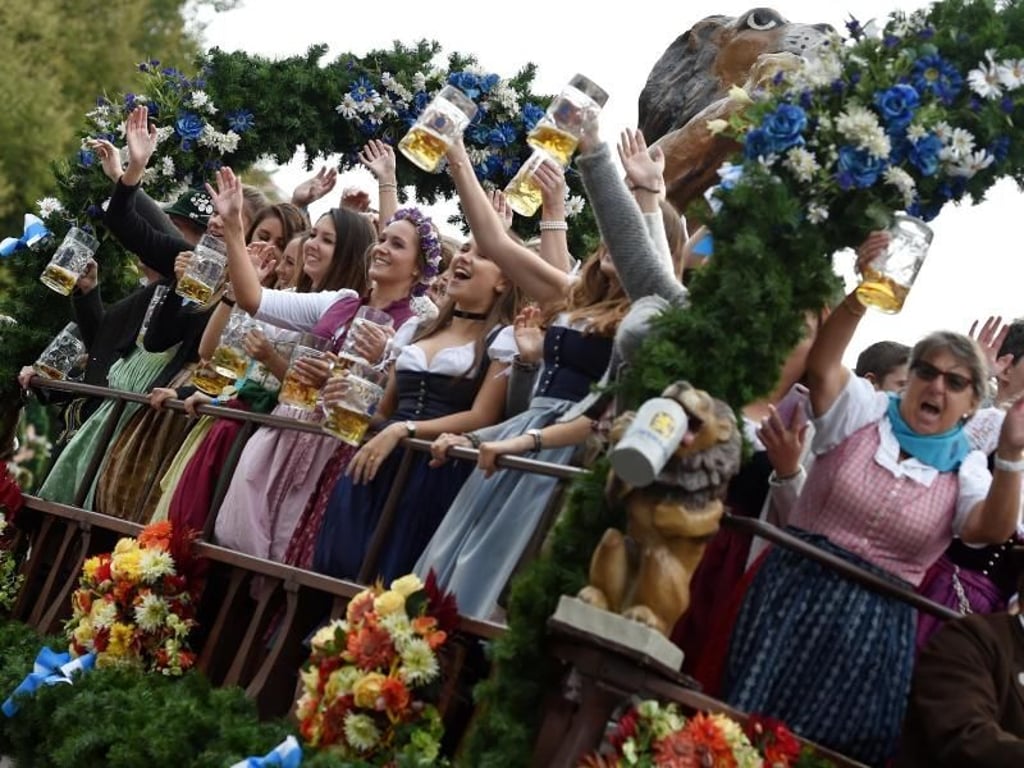 Bedienungen und Gäste feiern beim Einzug der Festwirte auf einem Wagen. Foto: Angelika Warmuth