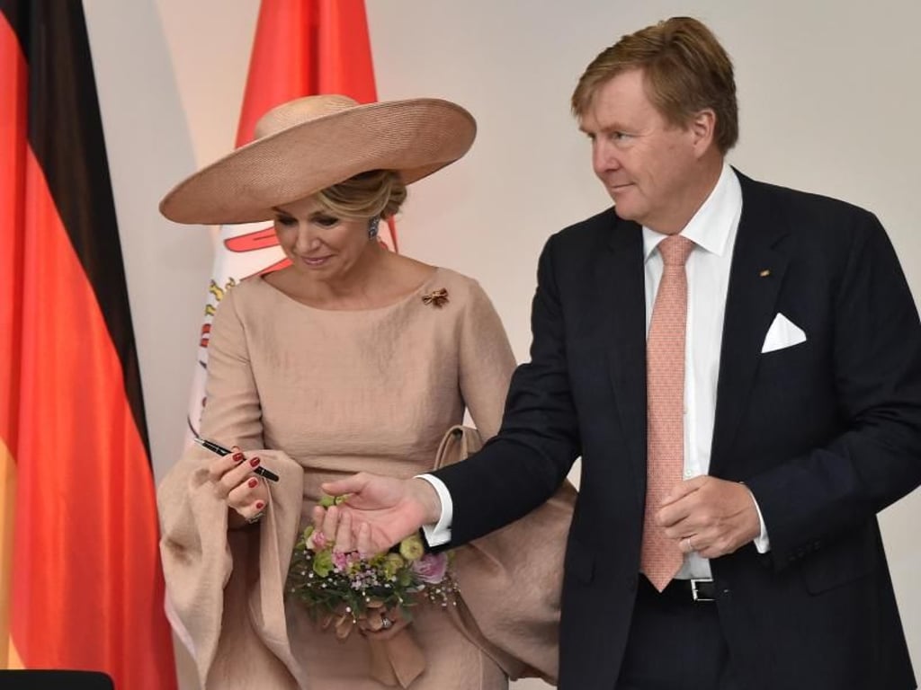 König Willem-Alexander reicht Königin Maxima den Stift für die Eintragung in das Goldene Buch der Staatskanzlei. Foto: Bernd Settnik