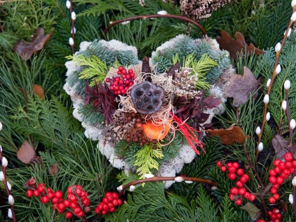 Gestecke mit besonderer Symbolkraft bieten sich für die Gräber der verstorbenen Liebsten an. Zu Weihnachten machen sich darin rote Elemente wie Scheinbeeren gut. Foto: Andrea Warnecke