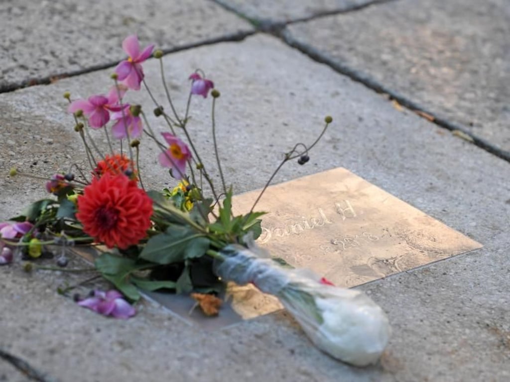 Blumen liegen an einer Gedenkplatte für den getöteten Daniel H. in Chemnitz. Foto: Hendrik Schmidt