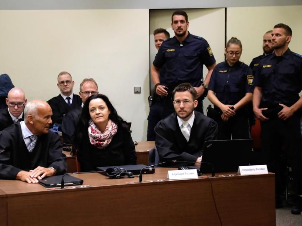 Beate Zschäpe zwischen ihren Anwälten Mathias Grasel (3.v.l.) und Hermann Borchert (l) bei der Fortsetzung des NSU-Prozesses im Gerichtssaal. Foto: Matthias Schrader/AP