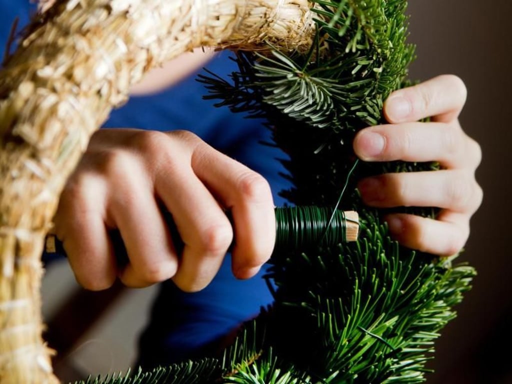 Die Zweige lassen sich mit grünem Basteldraht unauffällig am Strohrohling befestigen. Foto: Franziska Gabbert