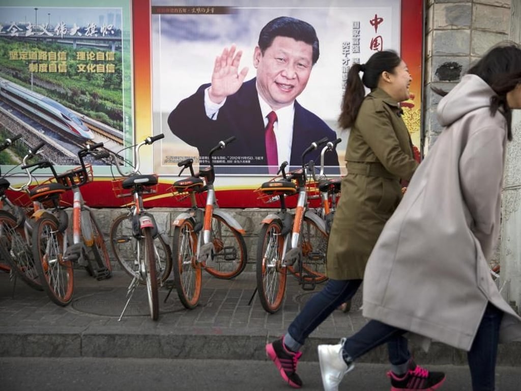 Allgegenwärtig: Chinesen laufen an einem Poster mit dem Konterfei von Präsident Xi Jinping vorbei. Foto: Mark Schiefelbein/AP