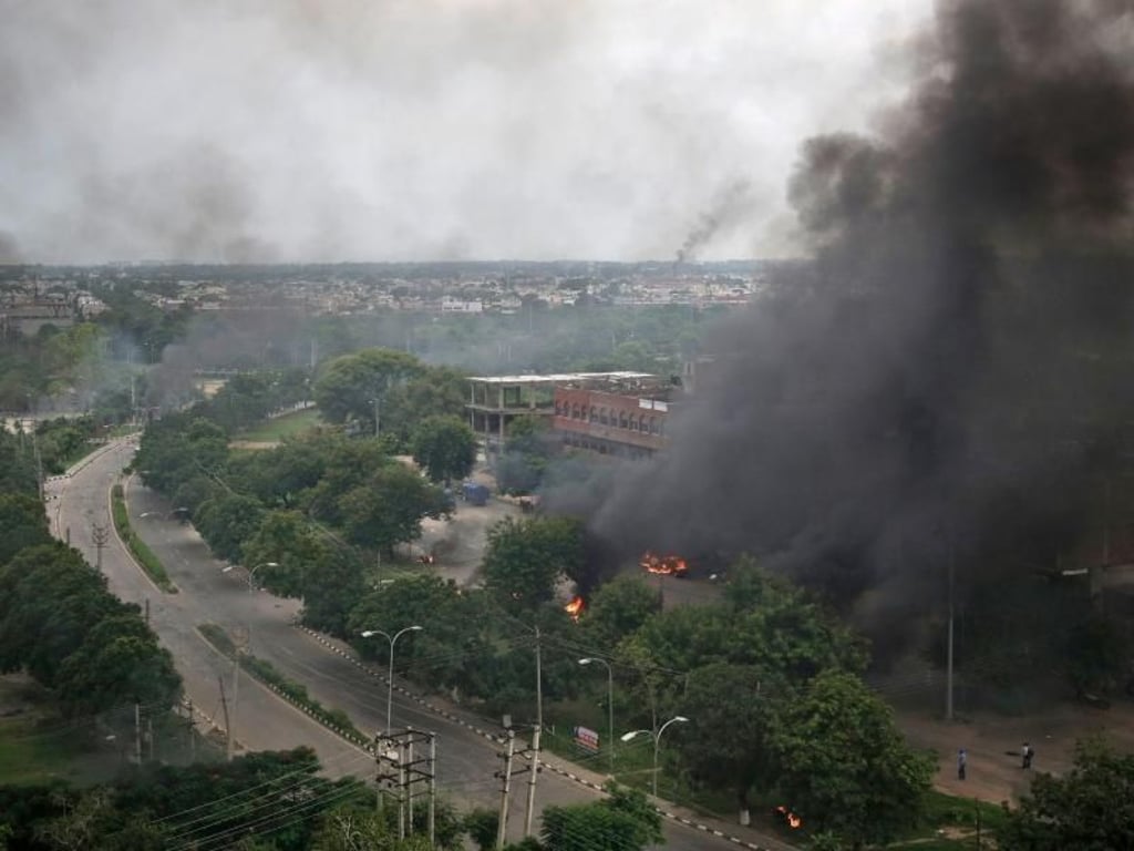 Rauch und Feuer über Panchkula (Indien). Hier protestieren Anhänger des Gurus gegen seine Verurteilung. Foto: Altaf Qadri