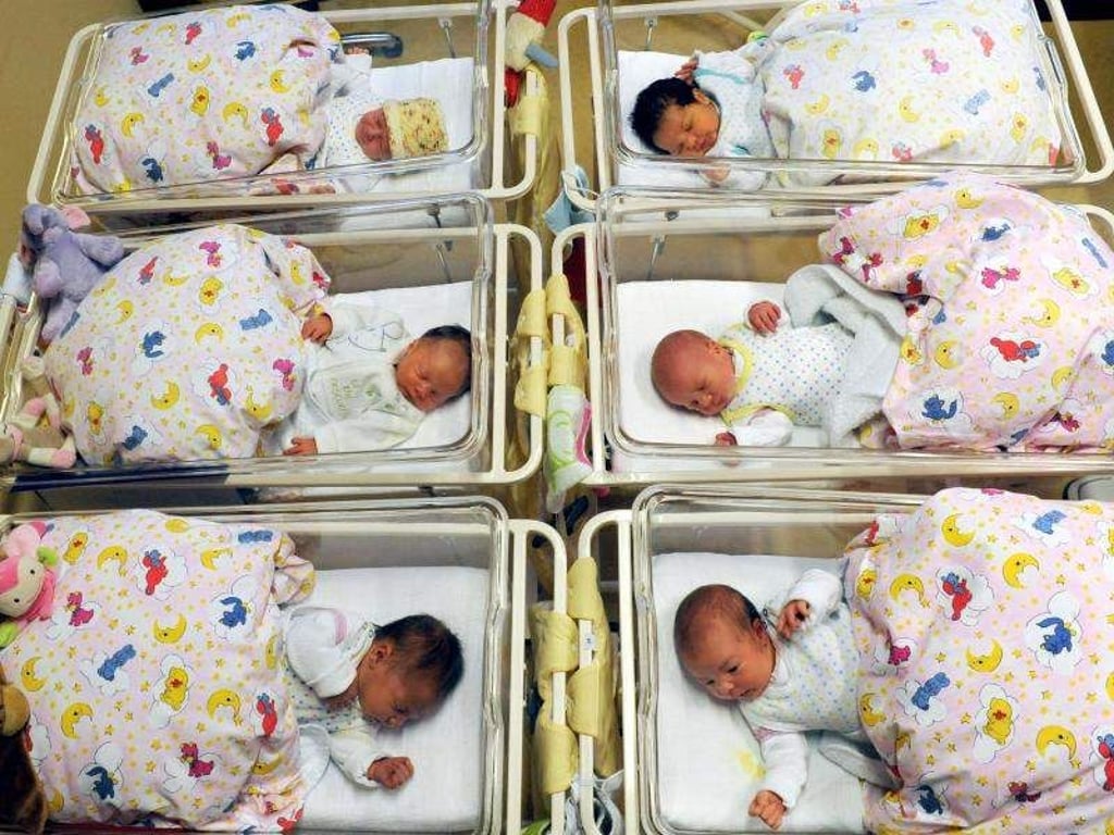 Auf der Neugeborenenstation eines Krankenhauses liegen Babys in ihren Bettchen. Foto: Waltraud Grubitzsch/Archiv