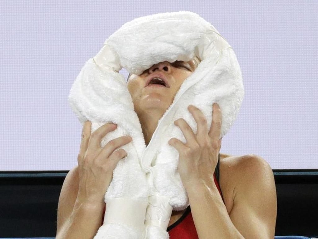 Simona Halep hält sich enttäuscht ein kaltes Handtuch ins Gesicht. Foto: Dita Alangkara