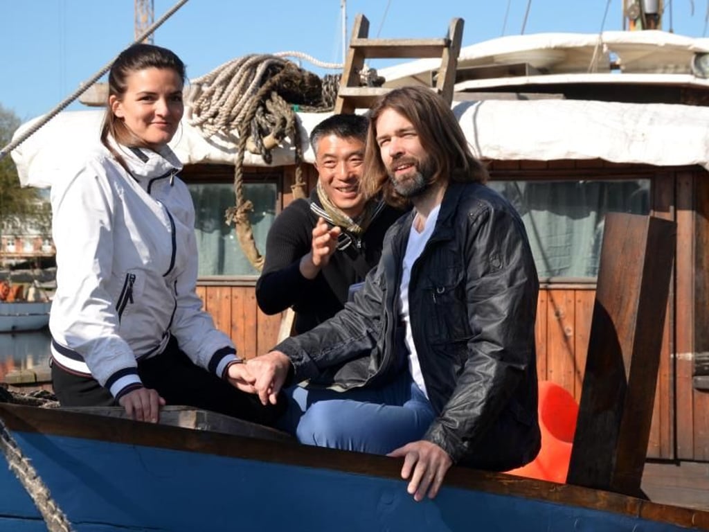 Frauke Rauner und Wolf Stein stellten im Greifswalder Museumshafen das Bild «Auf dem Segler» für den Fotografen Hiroyuki Masuyama (M) nach. Foto: Andreas Heimann