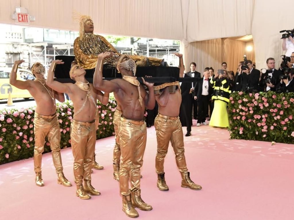 Der Entertainer Billy Porter schwebt auf einer Sänfte in den Saal, getragen von sechs gutgebauten Männern. Foto: Charles Sykes/Invision/AP