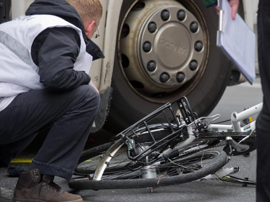 Unter dem Lkw: Polizisten und Gutachter bergen in Berlin ein völlig zertrümmertes Fahrrad. Foto: Tim Brakemeier