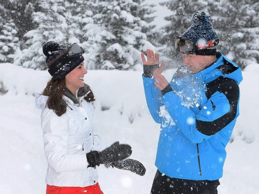 Herzogin Kate (l.) bewirft Prinz George (r.) mit einem Schneeball. Foto: John Stillwell