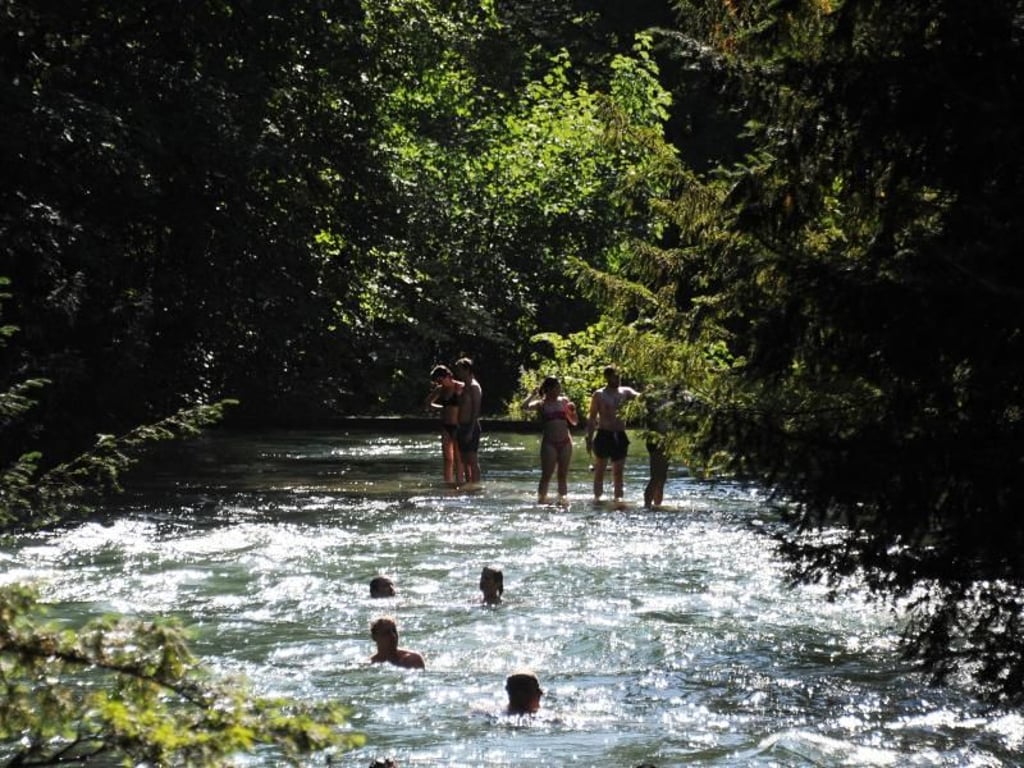 Jugendliche kühlen sich im Eisbach im Englischen Garten in München ab. Foto: Fabian Nitschmann