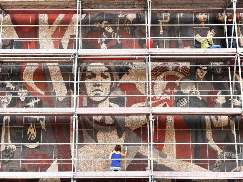 Studenten arbeiten am Wandbild «Der Weg der Roten Fahne», das sich an der Westfassade am Kulturpalast Dresden befindet. Es ist seit 2001 als Kulturdenkmal ausgewiesen. Foto: Jens Kalaene