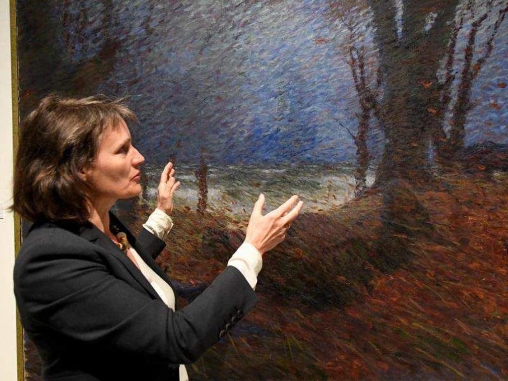 Kuratorin Uta Kuhl in der Ausstellung «Impressionist des Nordens - Hans Olde der Ältere» vor dem Bild «Hünengrab bei Bülk (Herbstturm am Meer)» aus dem Jahr 1894. Foto: Carsten Rehder