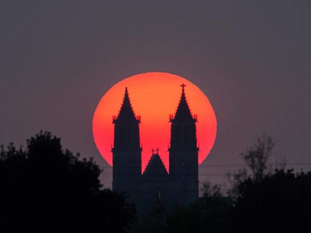 Die Abendsonne geht hinter dem Magdeburger Dom in Magdeburg unter. Foto: Lukas Schulze/Archivbild