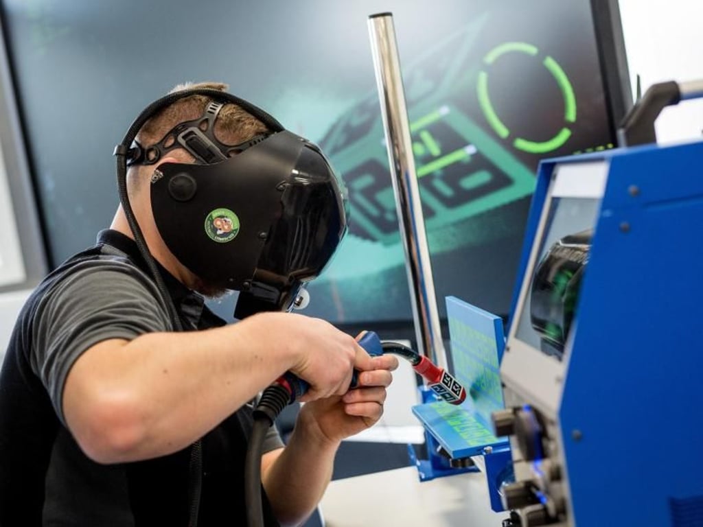 Ein Auszubildender arbeitet in einem Industrie-4.0-Labor an einer virtuellen Schweißmaschine. Foto: Christoph Schmidt