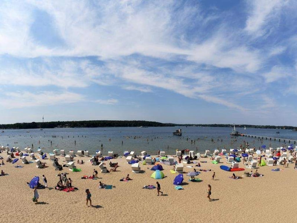 Badegäste genießen das hochsommerliche Wetter am Strandbad Wannsee. Foto: Ralf Hirschberger