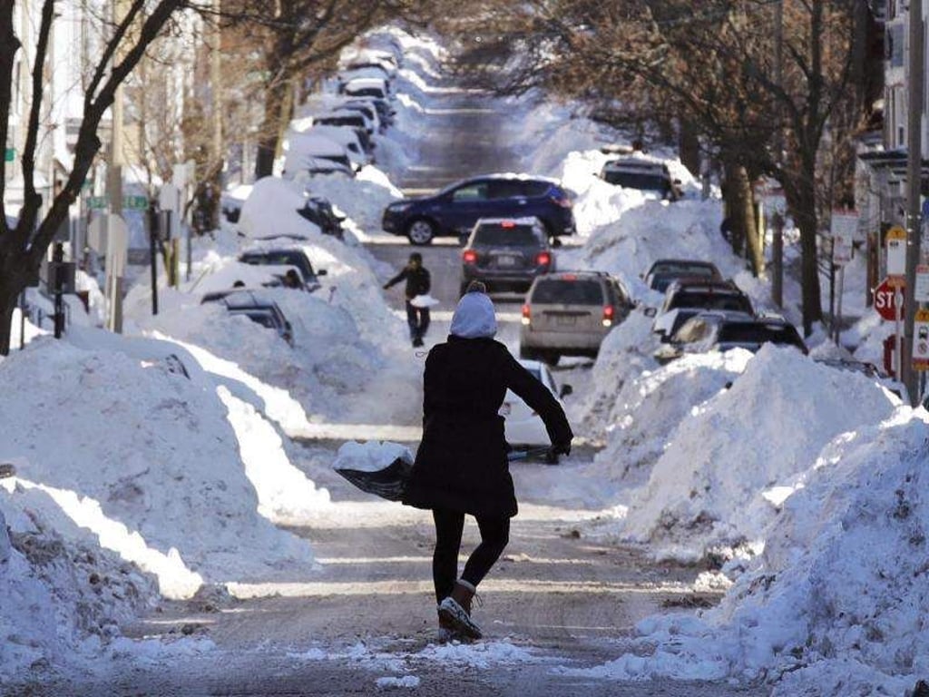 Eine Frau schaufelt im Süden von Boston Schnee von der Straße. Ein starker Wintersturm hat Teile der US-Ostküste fest in seinem Griff. Foto: Charles Krupa