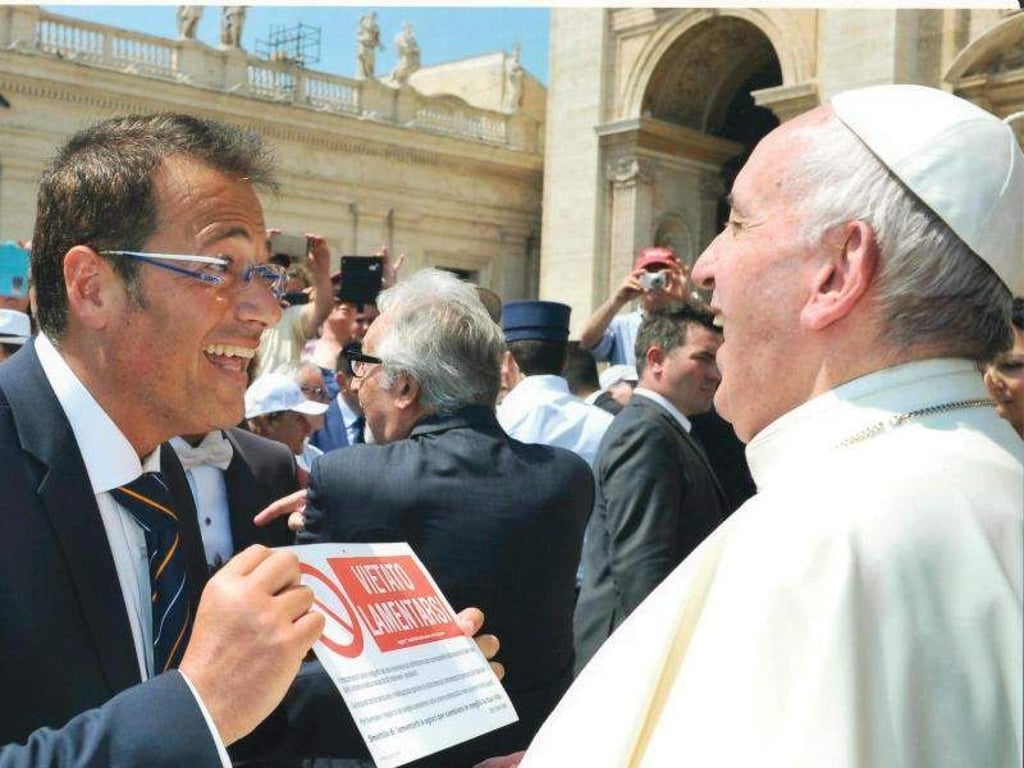 Papst Franziskus (r) freut sich über ein Schild mitder Aufschrift «VIETATO LAMENTARSI» (Kein Jammern), das der Psychologe und Motivationsredner Salvo Noé ihm überreicht. Foto: Salvo Noé