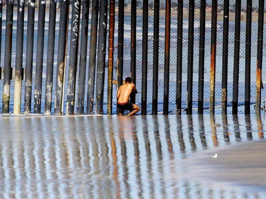 Unerreichbar: Ein Mann beobachtet durch den Grenzzaun bei Tijuana die amerikanische Seite. Foto: Alejandro Zepeda/EFE