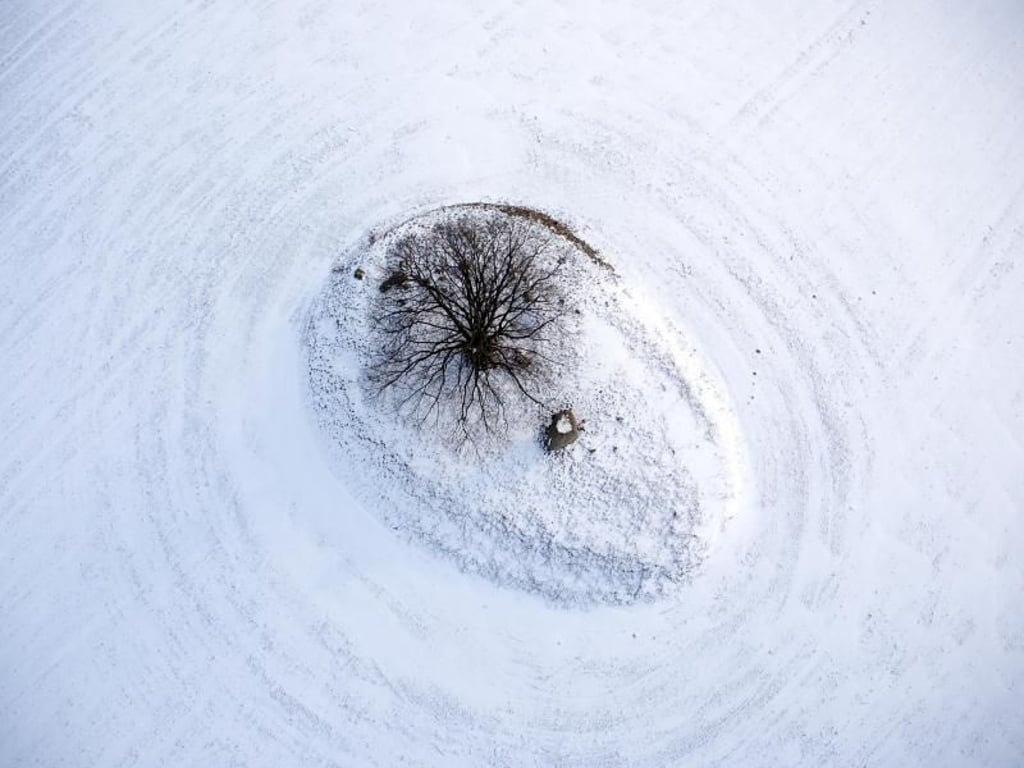 Ein mit Schnee bedeckter vorchristlicher Grabhügel in Mecklenburg-Vorpommern (Luftaufnahme mit einer Drohne). Foto: Jens Büttner