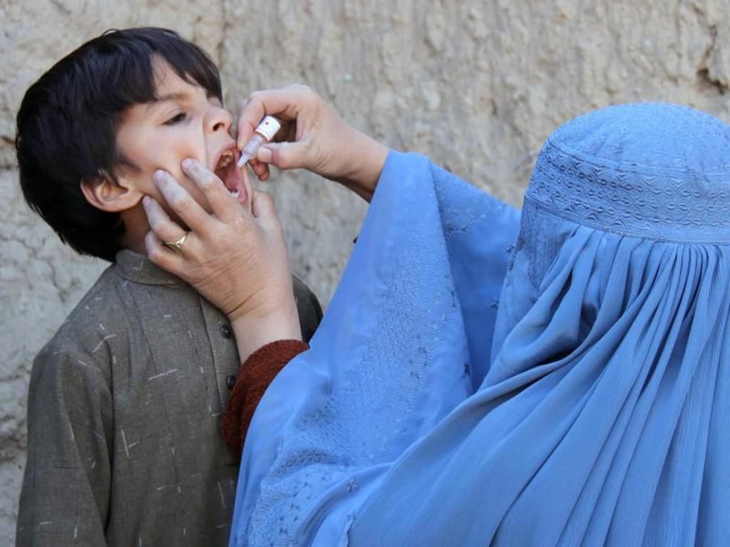 Eine Afghanin gibt einem Kind eine Polio-Impfung. Foto: Muhammad Sadiq/EPA