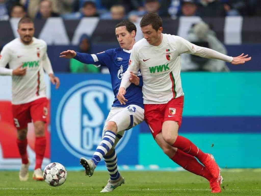 Schalkes Sebastian Rudy (l) spitzelt den Ball vor Augsburgs Michael Gregoritsch weg. Foto: Friso Gentsch