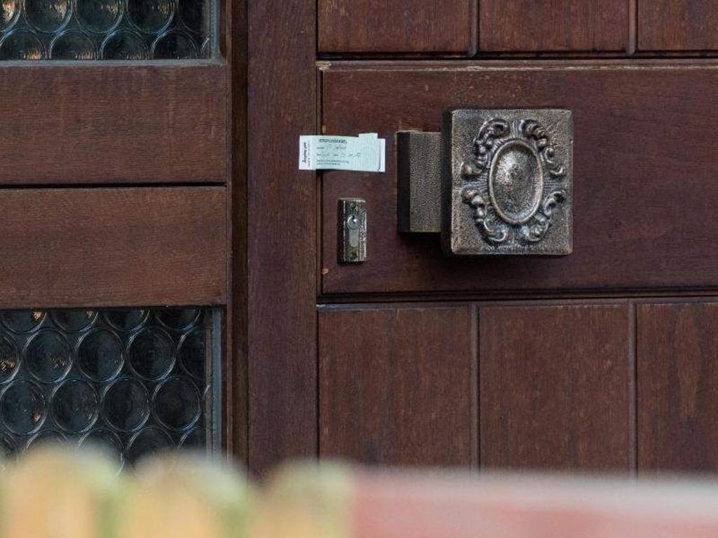 Ein Verschlusssiegel der Polizei ist an der Eingangstür des Einfamilienhauses angebracht. Foto: Armin Weigel