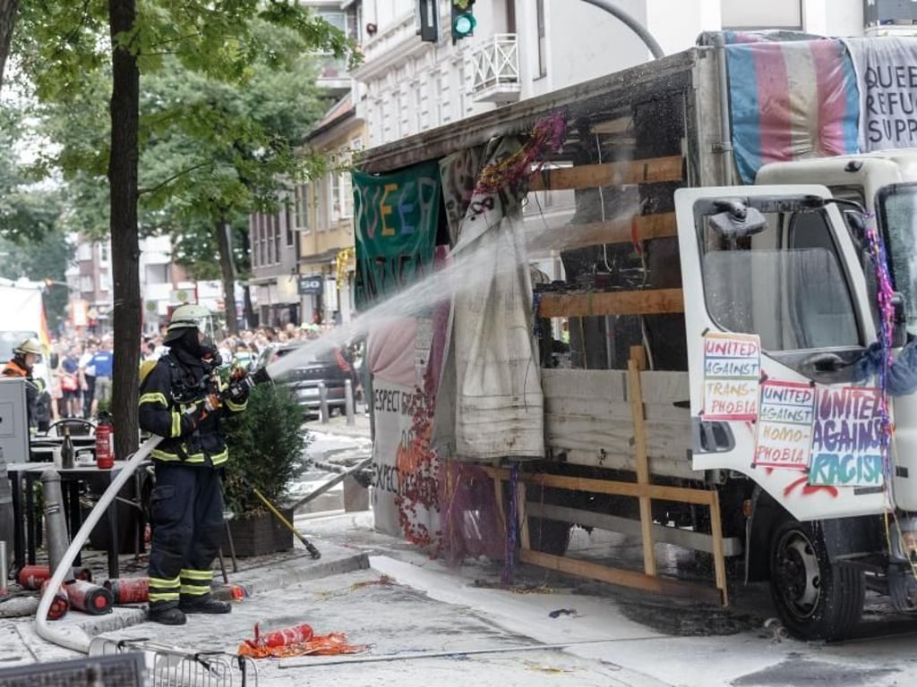 Feuerwehrmänner löschen den Truck, der bei der CSD-Parade zum Christopher Street Day Feuer fing. Foto: Markus Scholz