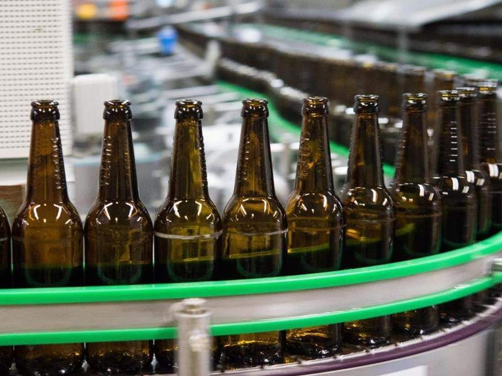 Gewaschene Bierflaschen laufen durch die Produktion einer Brauerei. Foto: Rainer Jensen