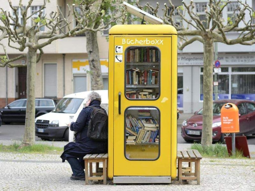 Ein Mann liest vor einer alten Telefonzelle ein Buch. Foto: Sonja Marzoner/Archiv