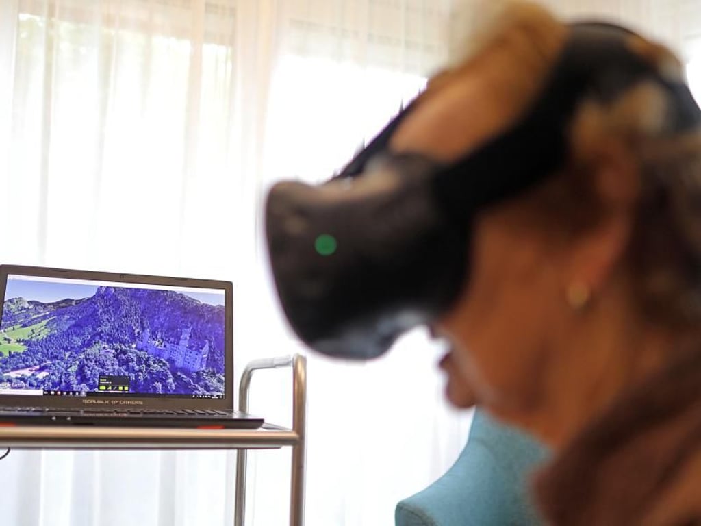 Maria Hertwig blickt im Caritas-Altenzentrum St. Maternus durch eine Virtual Realitiy Brille auf das Schloss Neuschwanstein. Foto: Oliver Berg