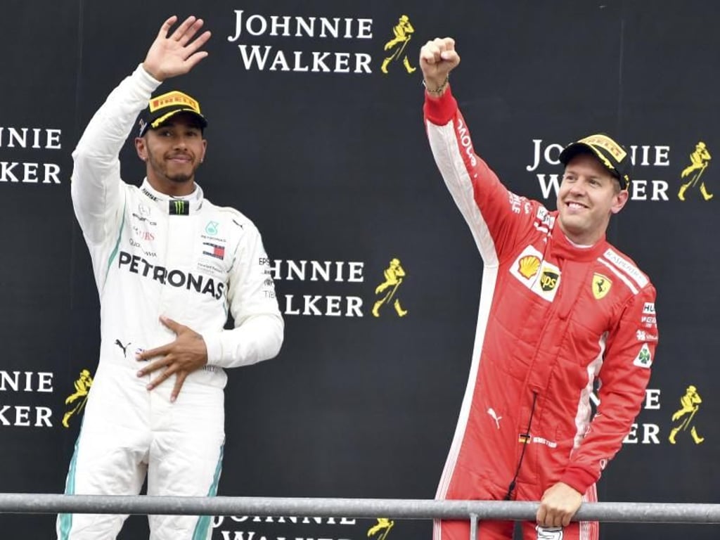 Sebastian Vettel und Lewis Hamilton stehen auf dem Podium. Foto: Geert Vanden Wijngaert/AP