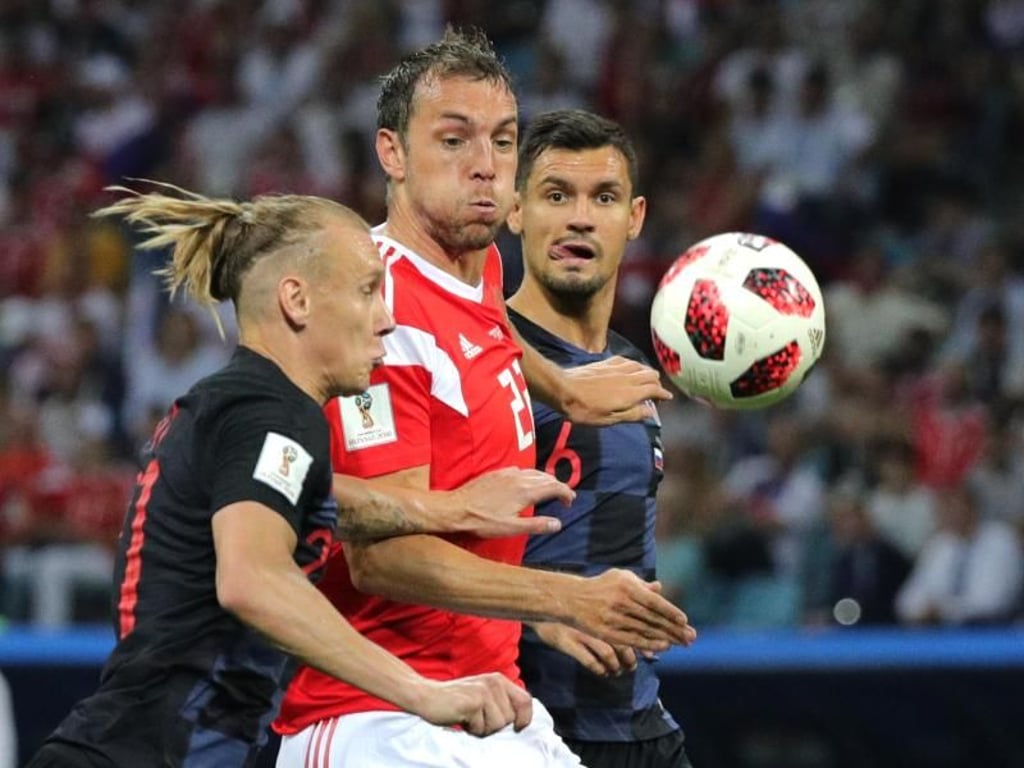An den Gesichtern ist die Anspannung zu erkennen: Der Russe Artjom Dsjuba (M) kämpft mti den Kroaten Domagoj Vida (l) und Dejan Lovren um den Ball. Foto: Christian Charisius
