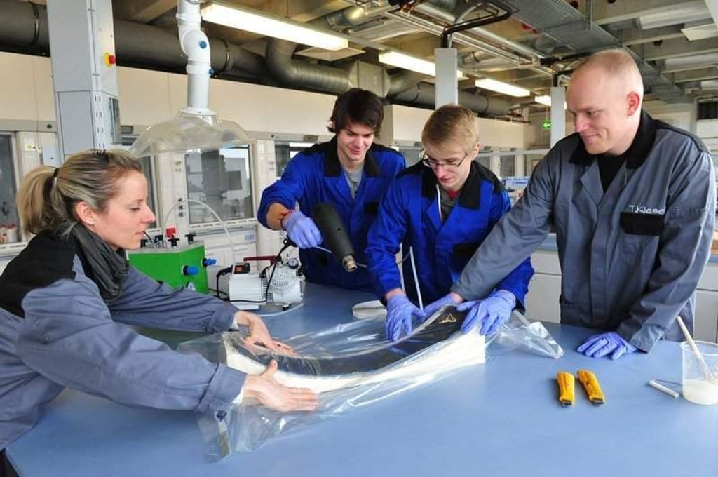 Foto: Uli LŸcke--Marcel Pawlowski, Robert Lazar und Arne Schwietering (v.r.) studieren im 3. Semester am Fachbereich fŸr Maschinenbau am Institut fŸr Ingenieurwissenschaften und Industriedesign an der Hochschule Magdeburg-Stendal. Hier bereiten sie gemeinsam mit Julia Schulz (wissenschaftliche Mitarbeiterin) die Herstellung eines Prototypenteils fŸr ein SchienenprŸfsystem vor. Im sogenannten Vakuumsackverfahren werden FaserverstŠrkte Kunststoffe wie Kohle,-oder Glasfasergewebe in eine ganz bestimmte Form mittels Vakuum gebracht. Werkstoffe aus Metall sollen durch solche hochfesten Kunststoffe an Maschinen und Fahrzeugen zur Gewichtsoptimierung eingestzt werden.