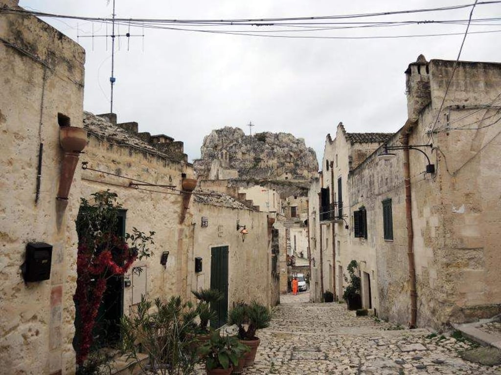 Über den Dächern Materas ragt auf einem wuchtigen Felsen ein Kreuz. 2019 ist die Stadt an Italiens Peripherie Kulturhauptstadt. Foto: Lena Klimkeit