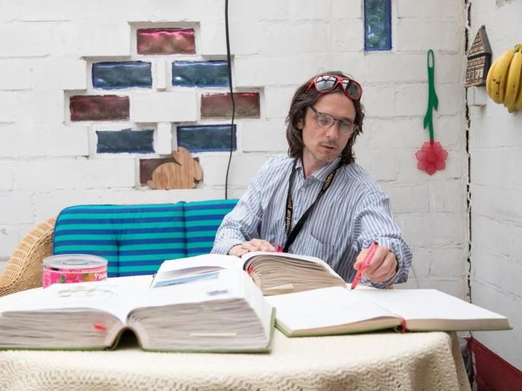 Der Künstler Jeremy Deller sitzt in einem Kleingarten vor seiner kulturanthropologischen Arbeit «Speak to the Earth and it will tell you (2007-2017)». Foto: Friso Gentsch