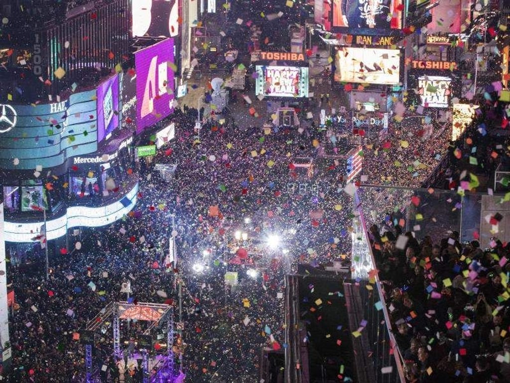Auf dem Times Square in New York (USA) findet jedes Jahr die größte Silvesterparty des Jahres statt. Um Mitternacht gibt es traditionellerweise einen Konfettiregen. Foto: Mary Altaffer/AP/dpa