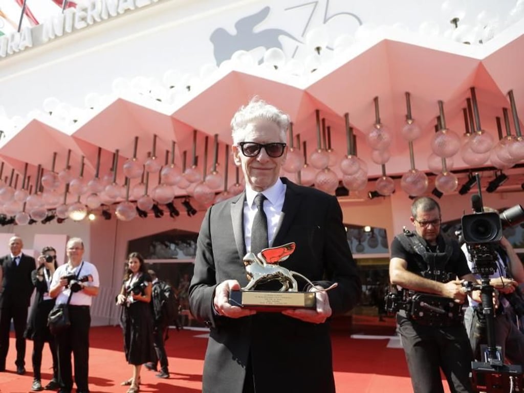 David Cronenberg mit dem Ehrenlöwen vor dem Festivalgebäude auf dem Lido. Foto: Kirsty Wigglesworth/AP