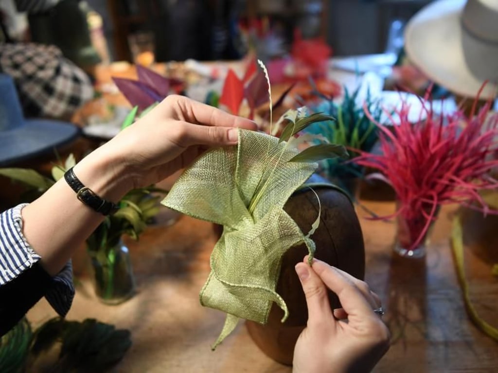 Zum Schluss die Dekoration: Nach der Ausbildung können sich Modisten zum Beispiel selbstständig machen, manche finden auch Jobs beim Theater. Foto: Ina Fassbender