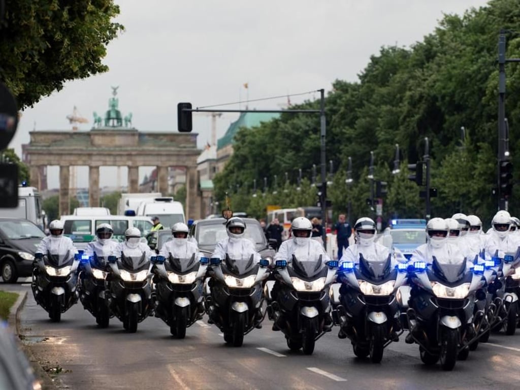 Polizisten auf Motorrädern eskortieren die britische Königin Elizabeth II. und Prinz Philip auf dem Weg vom Brandenburger Tor zum Schloss Bellevue. Foto: Gregor Fischer