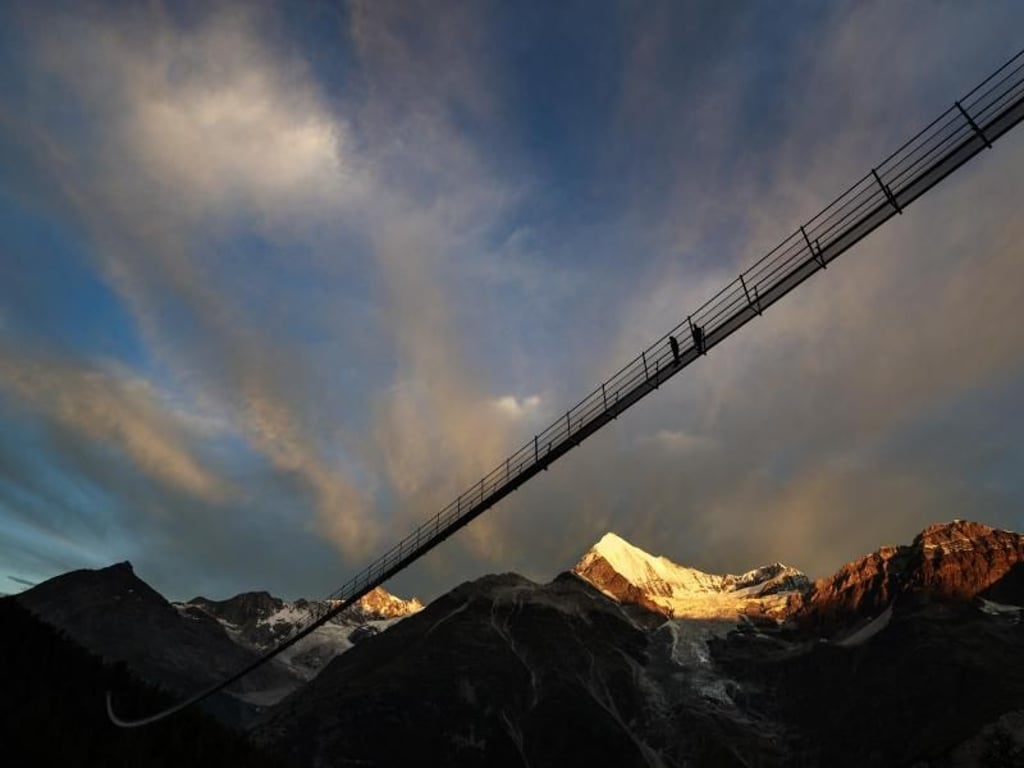 «Europabrücke» im schweizerischen Randa. Die fast 500 Meter lange Hängebrücke lädt schwindelfreie Wanderer in der Schweiz seit Samstag zur Überquerung des Grabengufers bei Zermatt ein. Foto: Valentin Flauraud