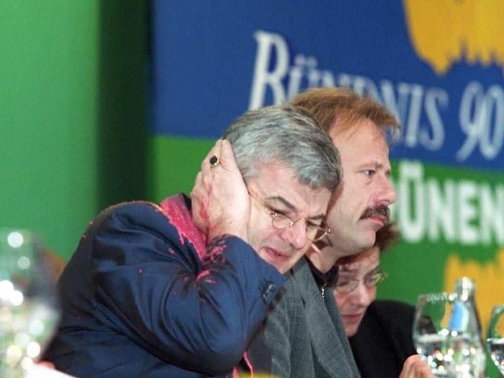 Von einem Farbbeutel getroffen, fasst sich Joschka Fischer am 13.5.1999 auf dem Sonderparteitag der Grünen in Bielefeld erschrocken ans Ohr. Foto: Gero Breloer