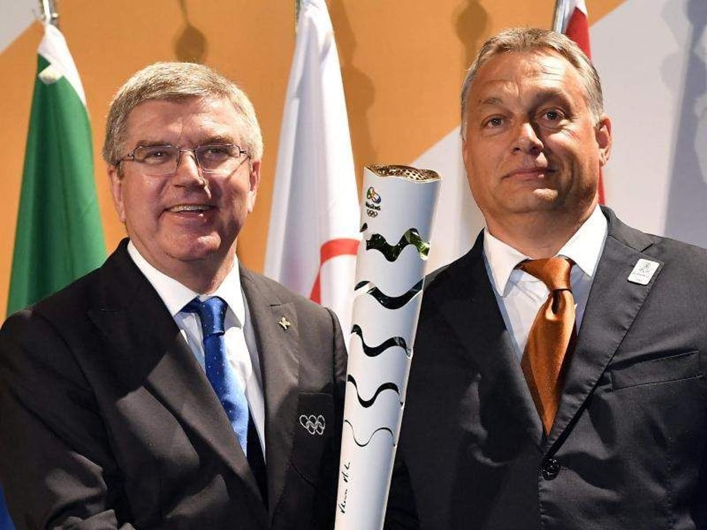 Noch optimistisch posiert Ministerpräsident Viktor Orban (r) mit IOC-Chef Thomas Bach und olympischer Facke. Foto: Tibor Illyes