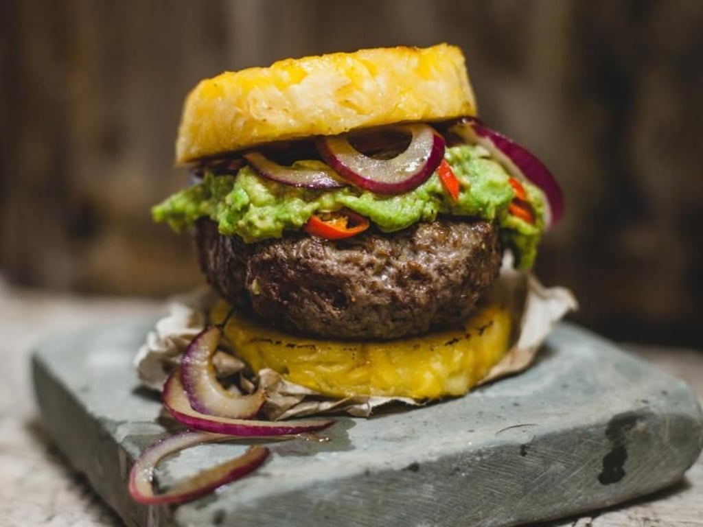 Die Ananas-Scheiben als Brötchen-Ersatz machen den Paleo-Burger zu einem herzhaft-süßen Genuss. Foto: Christian Verlag/Silvio Knezevic