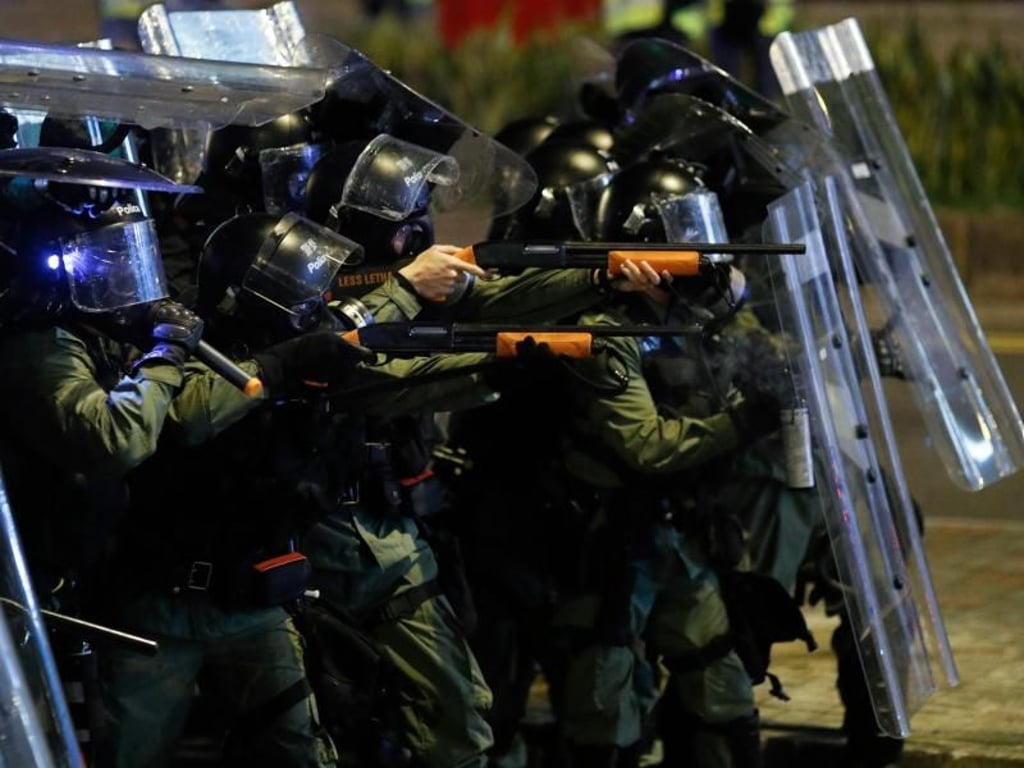 Polizisten richten Waffen auf Demonstranten. Foto: Vincent Yu/AP