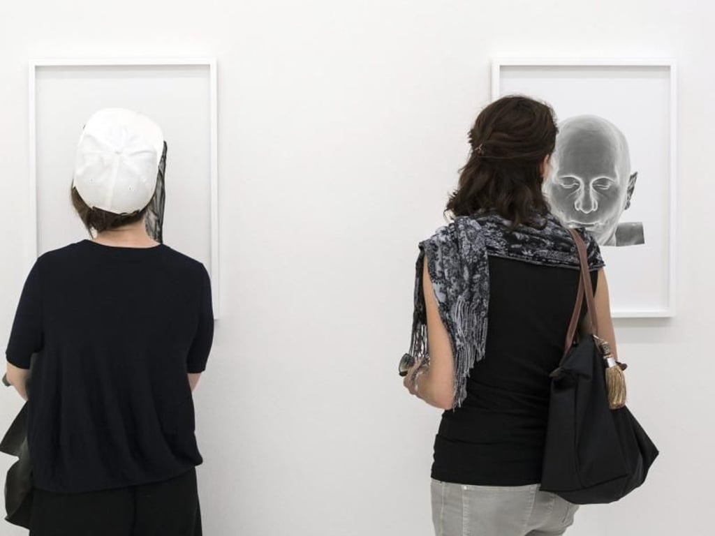 Besucher der Manifesta betrachten Werke des französischen Schriftstellers und Künstlers Michel Houellebecq. Foto: Ennio Leanza