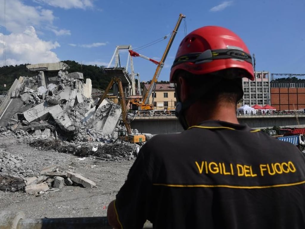 Ein Feuerwehrmann vor den Trümmern der eingestürzten Autobahnbrücke. Foto: Luca Zennaro/ANSA/AP