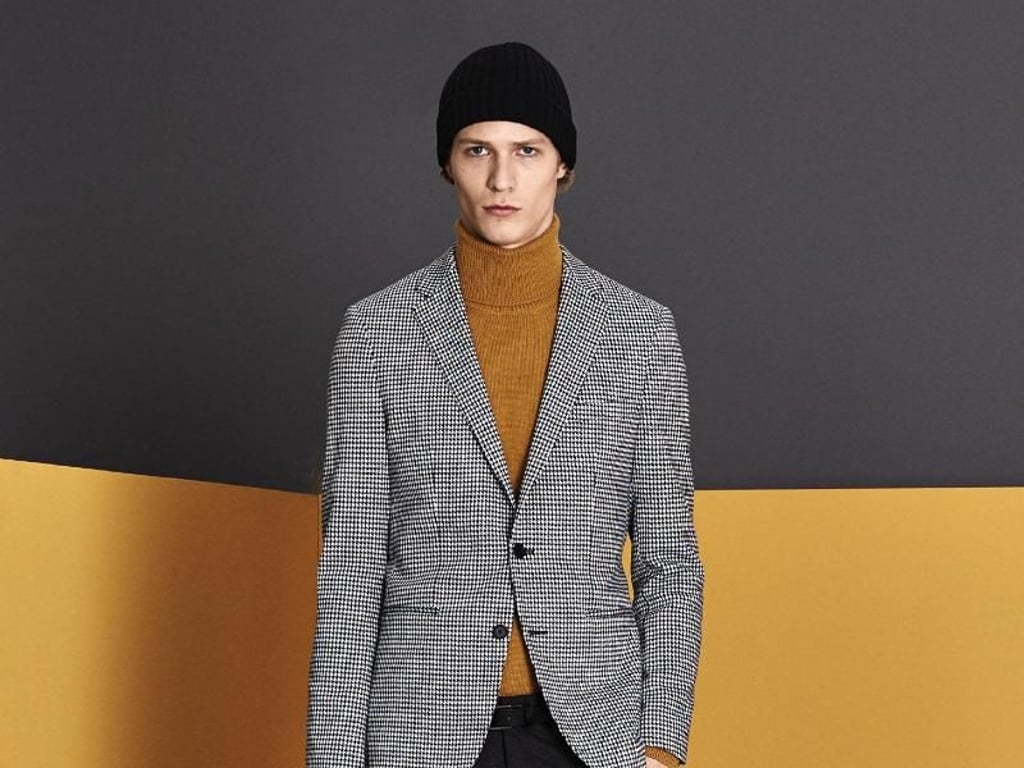 Moderne Silhouette: In Kombination mit Bundfaltenhose und Sakko wirkt dieser Rollkragenpullover in angesagtem Currygelb sehr lässig (Pullover 279 Euro, Jacke 499 Euro, Hose 249 Euro, Mütze 95 Euro, Tasche 650 Euro). Foto: Boss