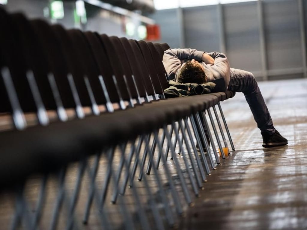 Ein Mann schläft in der Messehalle. Foto: Frank Rumpenhorst